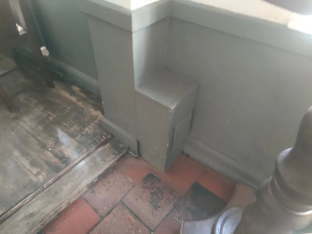 water-damaged floorboards beside bar seating area before leak detection works