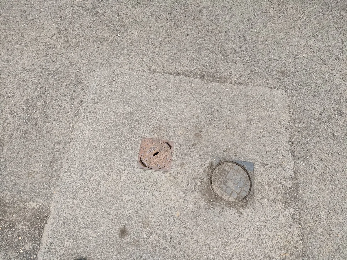 two water meter chambers in external tarmac surface during leak detection