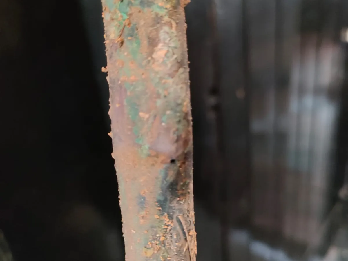 fault identified at squashed and corroded section of copper mains pipe below floor — leak located at