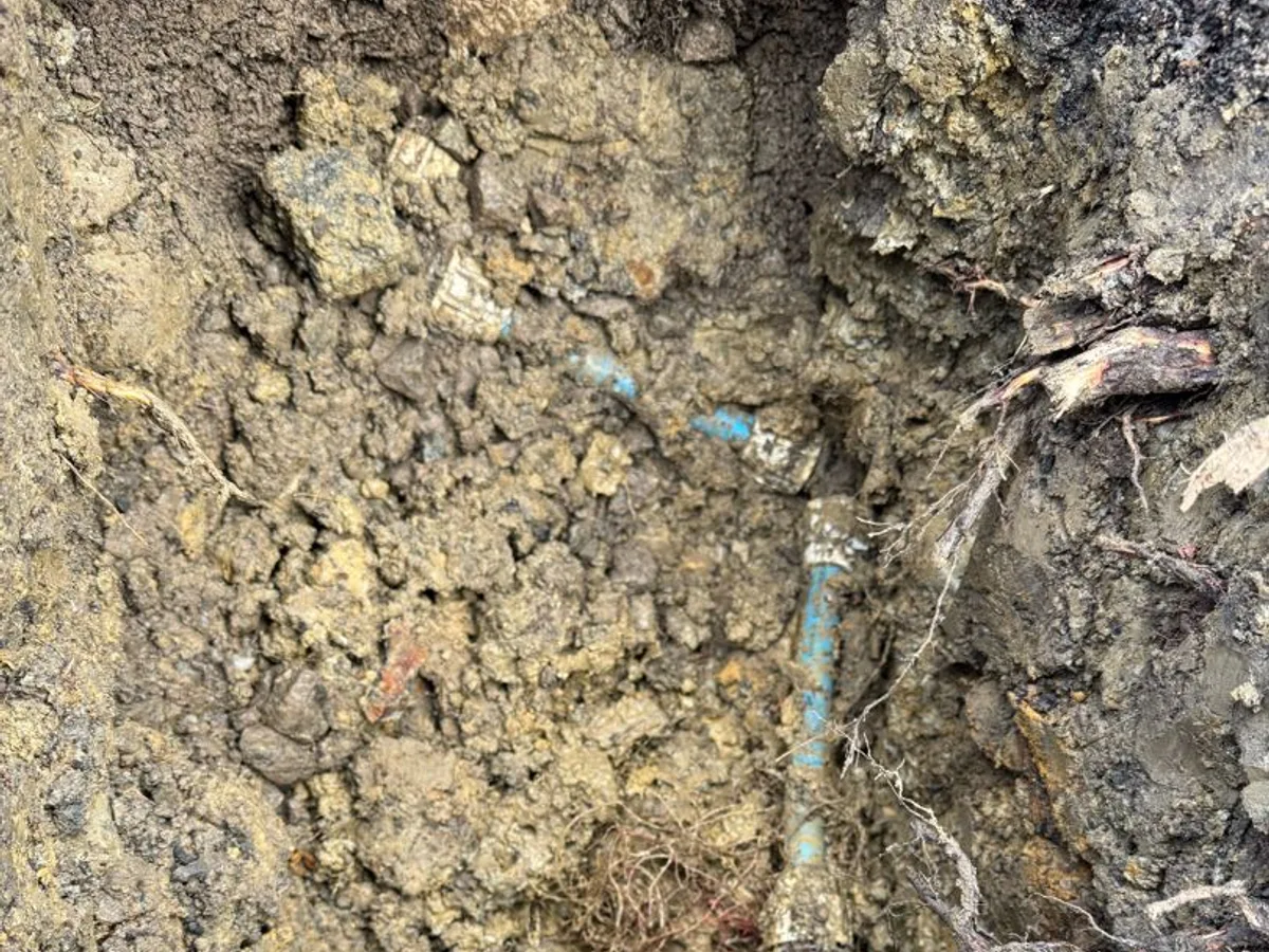 leak located at failed connection coupling on copper mains supply pipe exposed in excavation