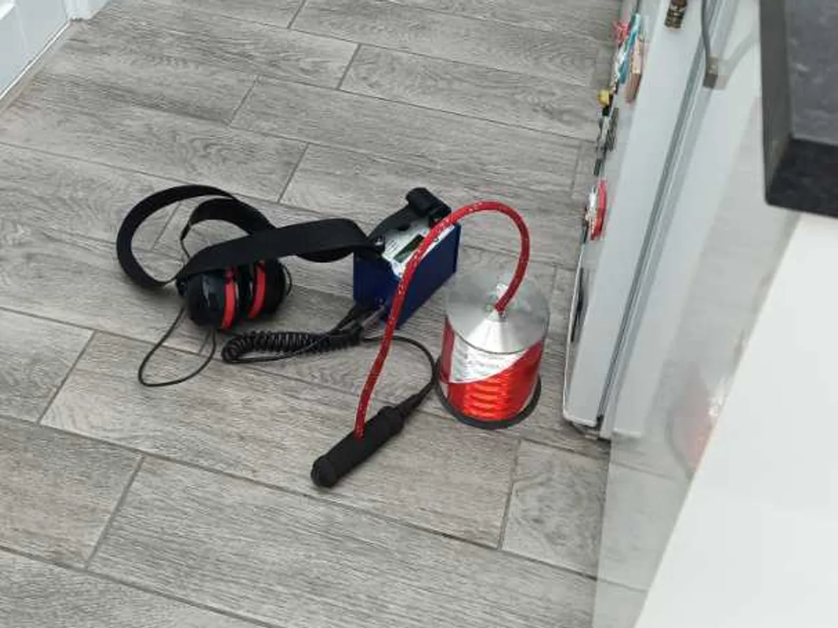acoustic listening headset and detector unit on kitchen floor during leak detection