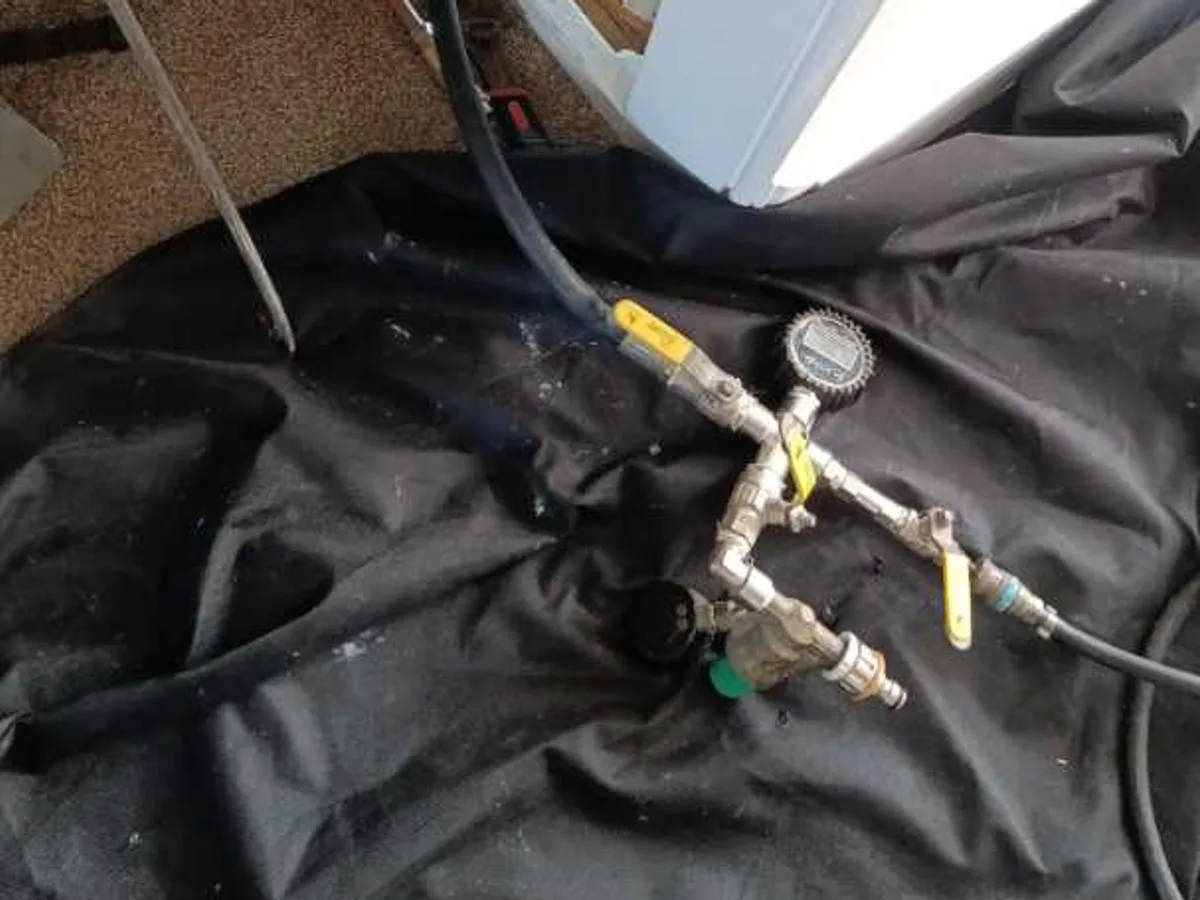 tracer gas pressure test rig connected at lifted floorboards during leak detection
