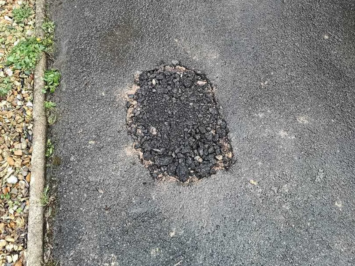 tarmac driveway patch reinstated after repair to underground mains supply pipe