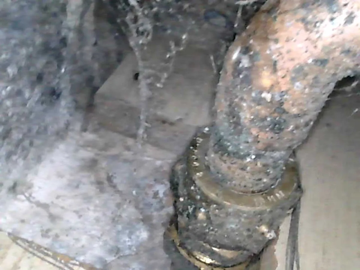 leak located at pinhole in 15mm cold mains copper pipe spraying water in excavation