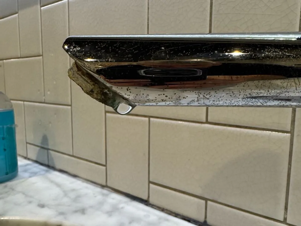 leak located at dripping chrome bar tap spout above marble basin surround