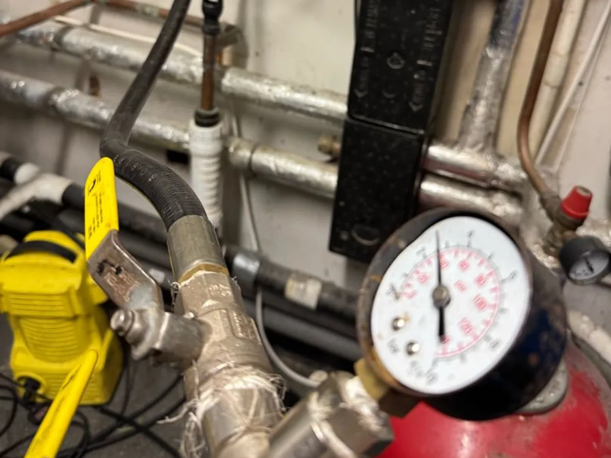 pressure test gauge connected to cold mains pipework in plant room during investigation — during leak detection