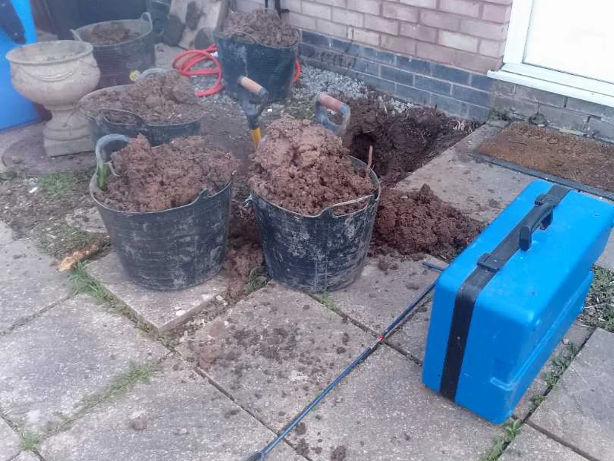 fault identified at excavated area to front of property with buckets of spoil removed — leak located at