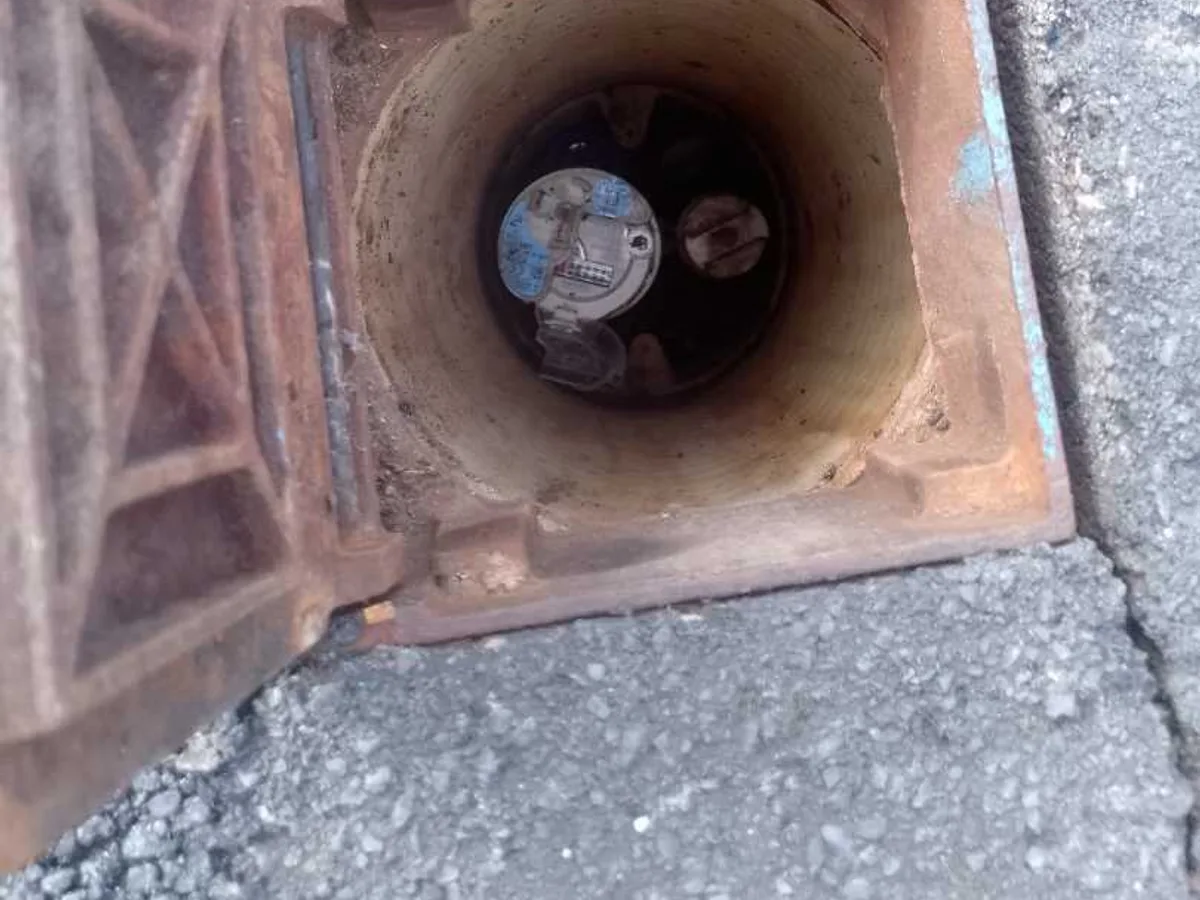 open water meter chamber at driveway during leak detection