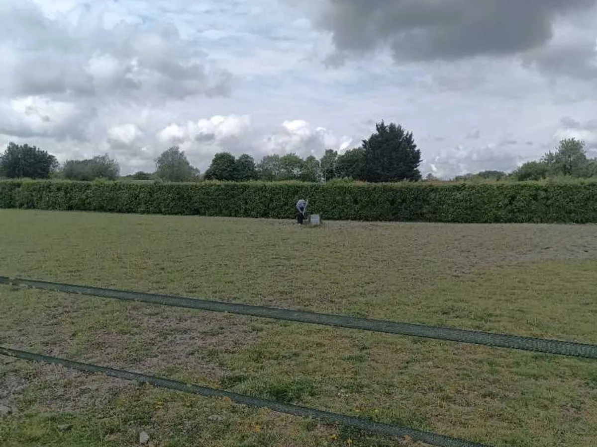 engineer surveying open farm field with water troughs during leak detection