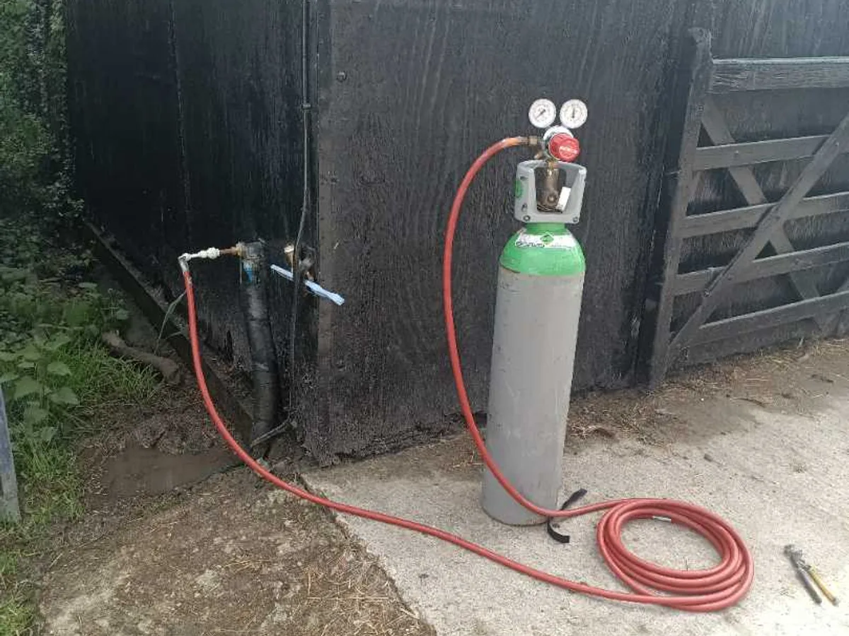 tracer gas cylinder connected to barn stopcock in use during leak detection investigation
