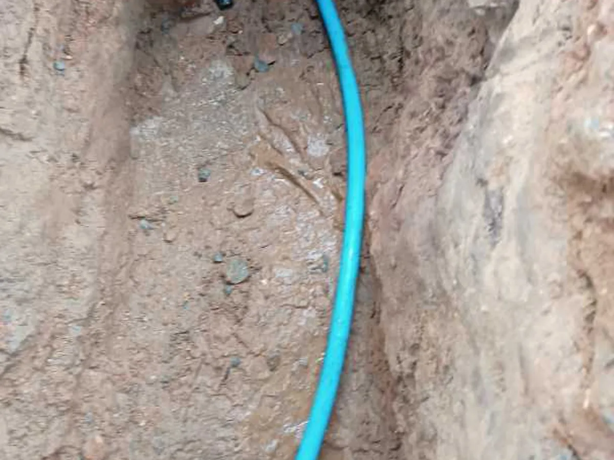 new 25mm blue MDPE pipe with compression fittings installed as repair completed in trench