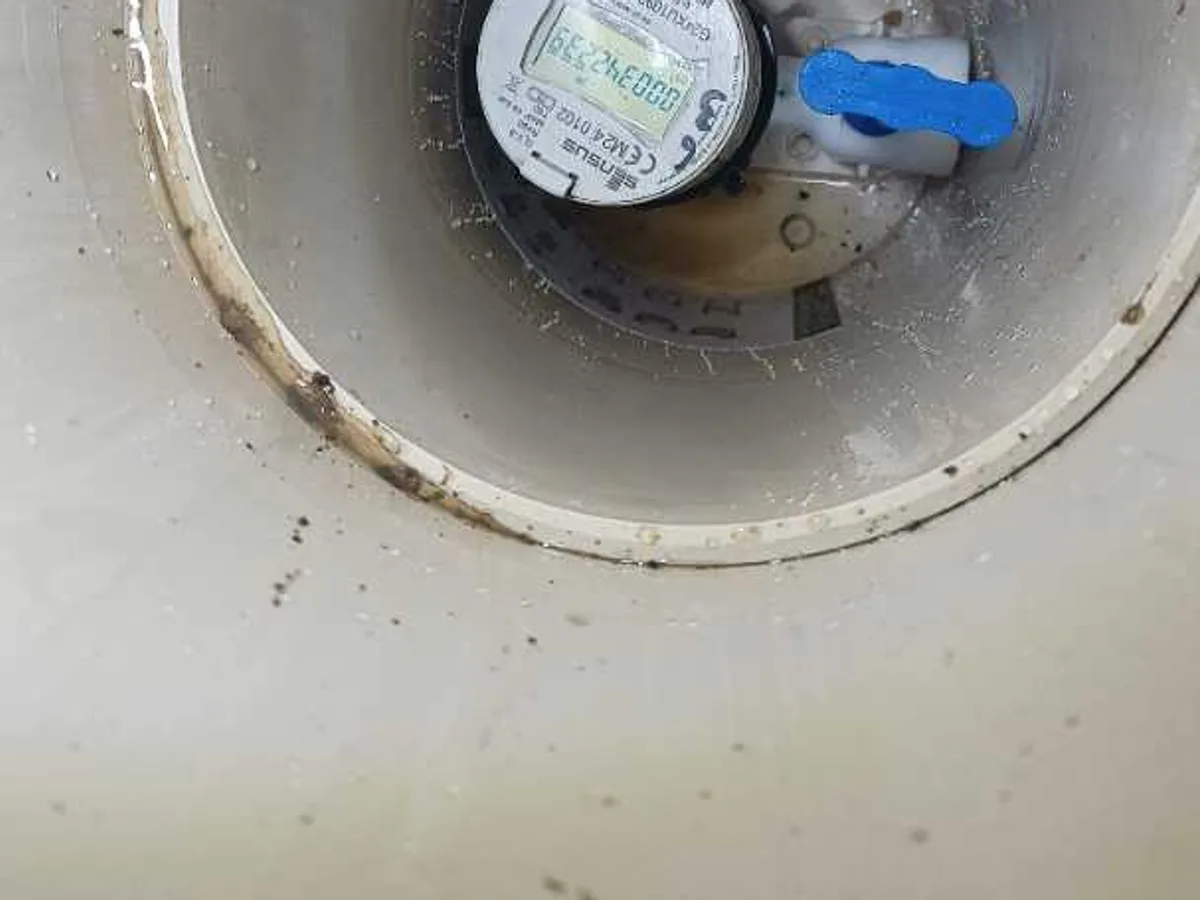 water meter inside footpath chamber inspected during leak detection survey