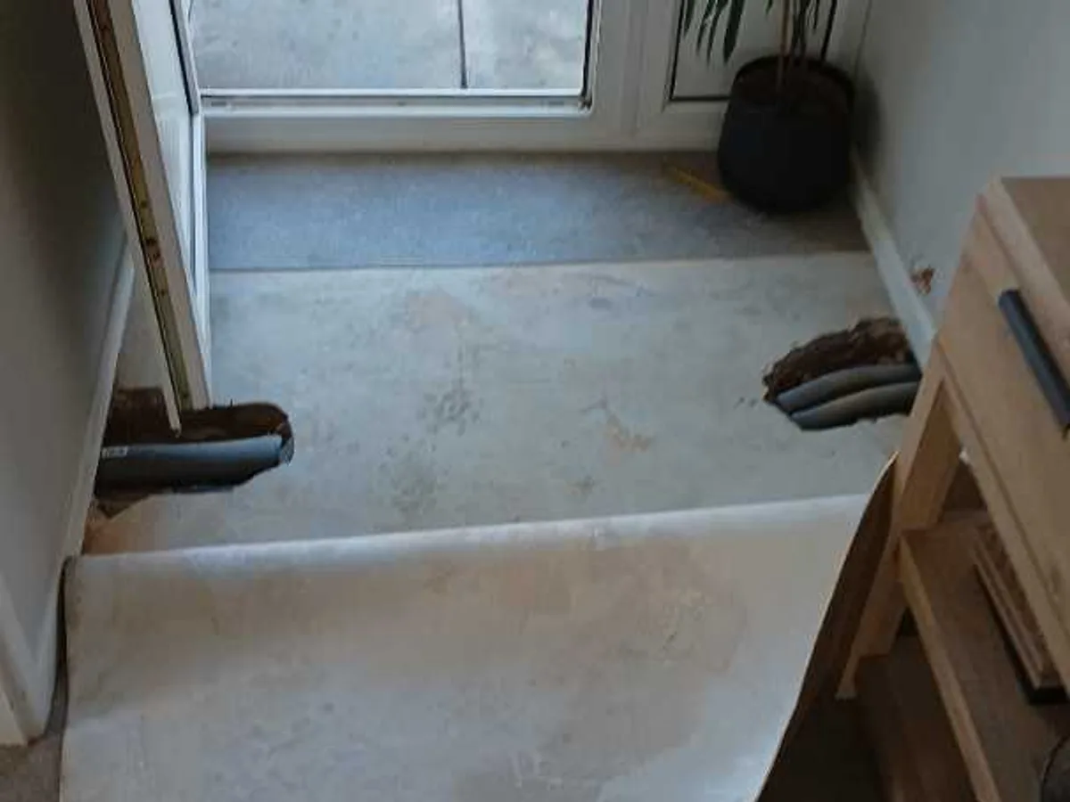 hallway floor area with lifted vinyl sheet after works completed showing repaired concrete beneath