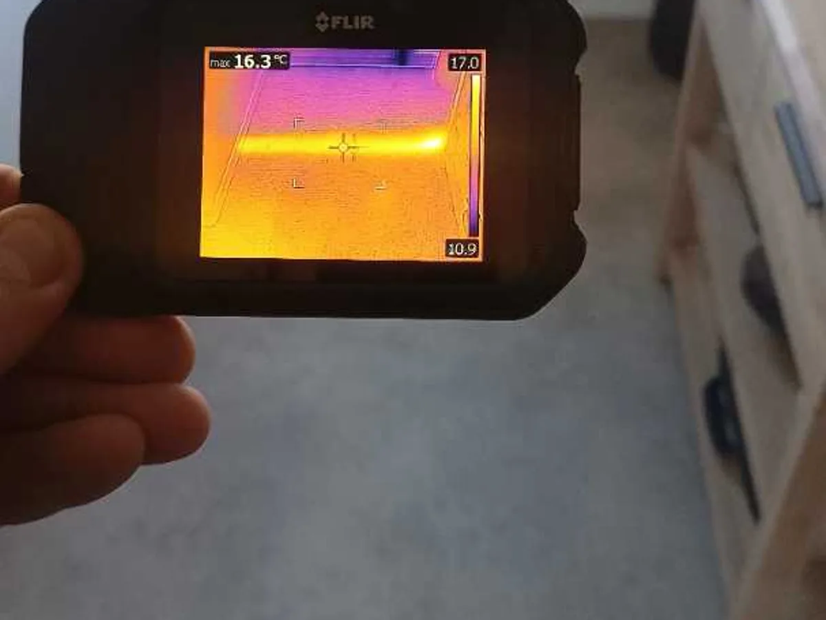 thermal imaging camera screen showing hot pipe run beneath floor during leak detection