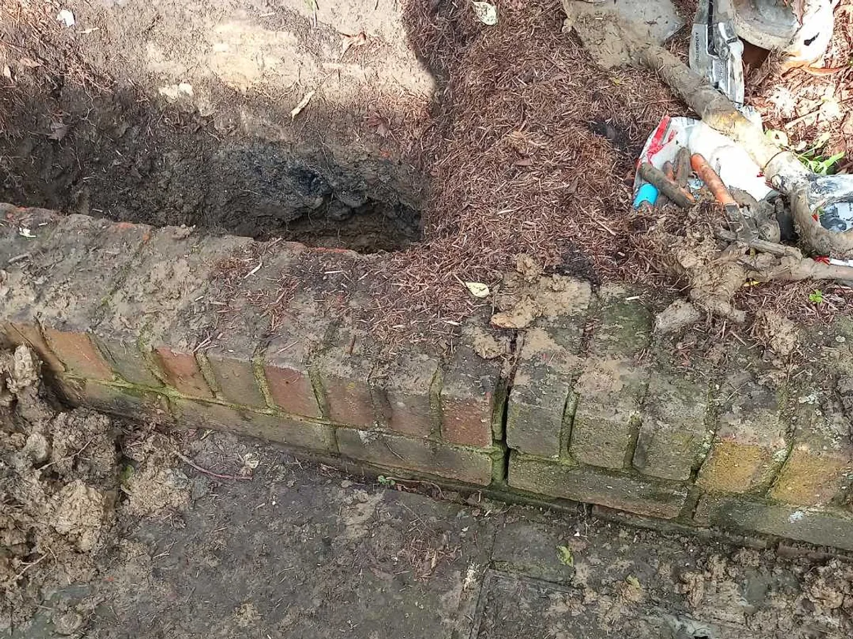 fault exposed at excavated garden border where mains enters property beneath brick edging