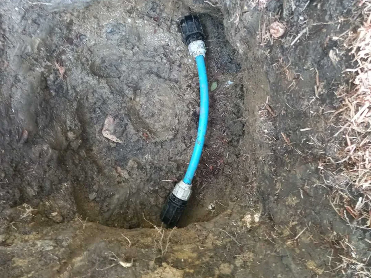 new 25mm MDPE pipe with universal transition couplings installed as repair completed in excavation