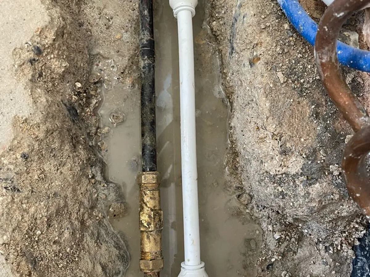 new 15mm plastic pipe section installed alongside corroded copper pipe as repair completed