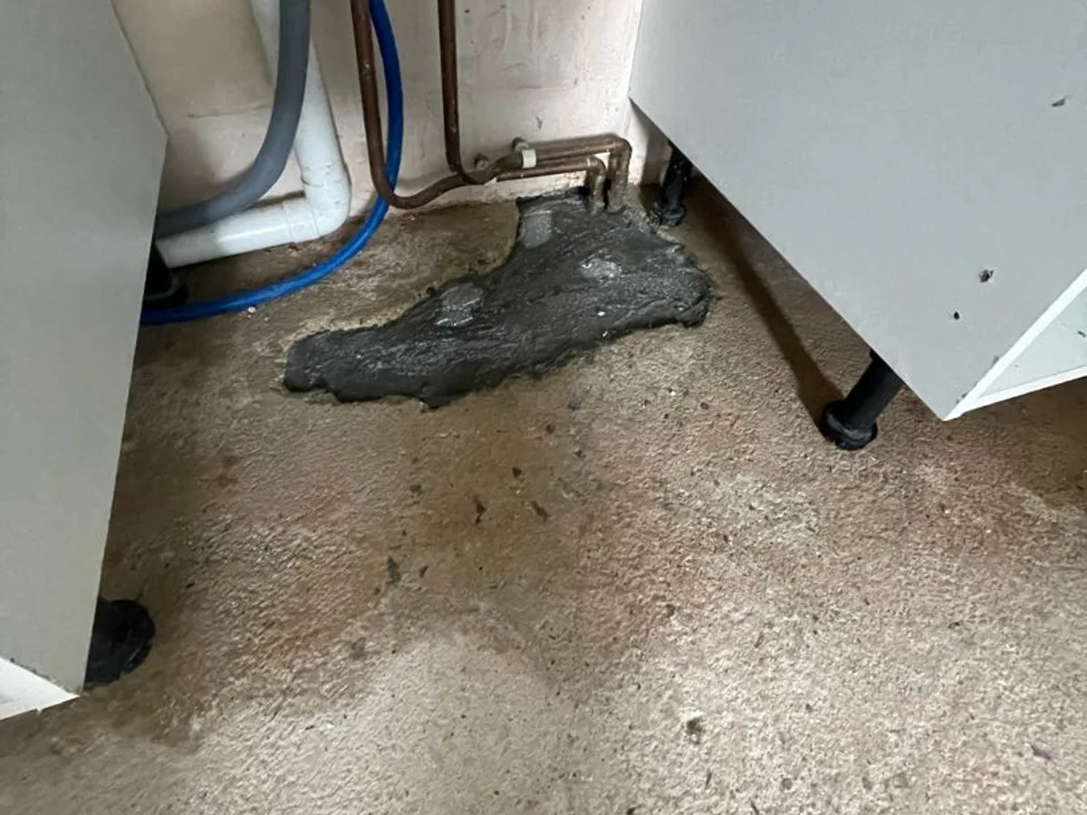 leak found at previous repair location with water pooling beneath utility room sink