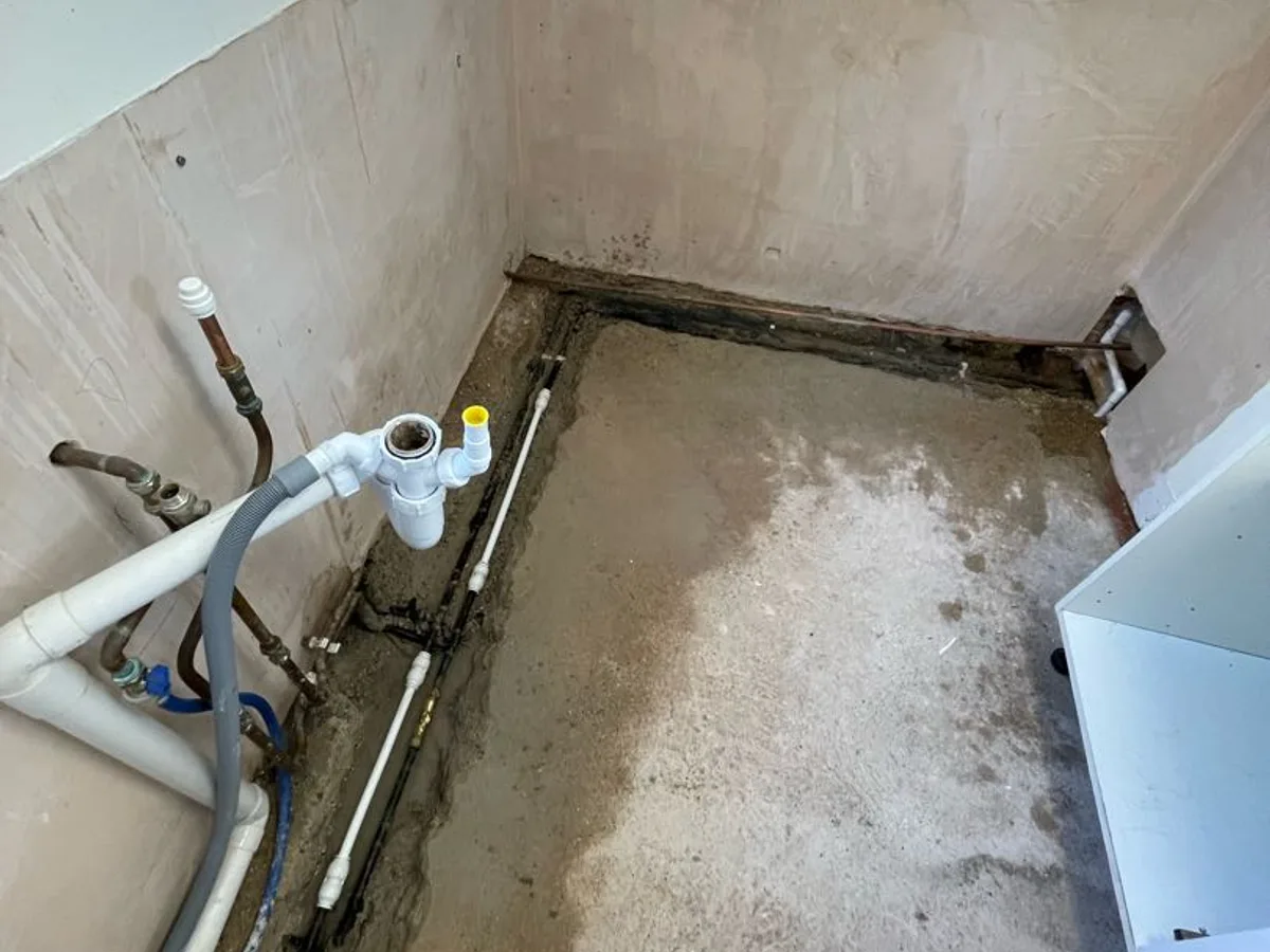 utility room floor units removed exposing pipework in concrete slab during leak detection