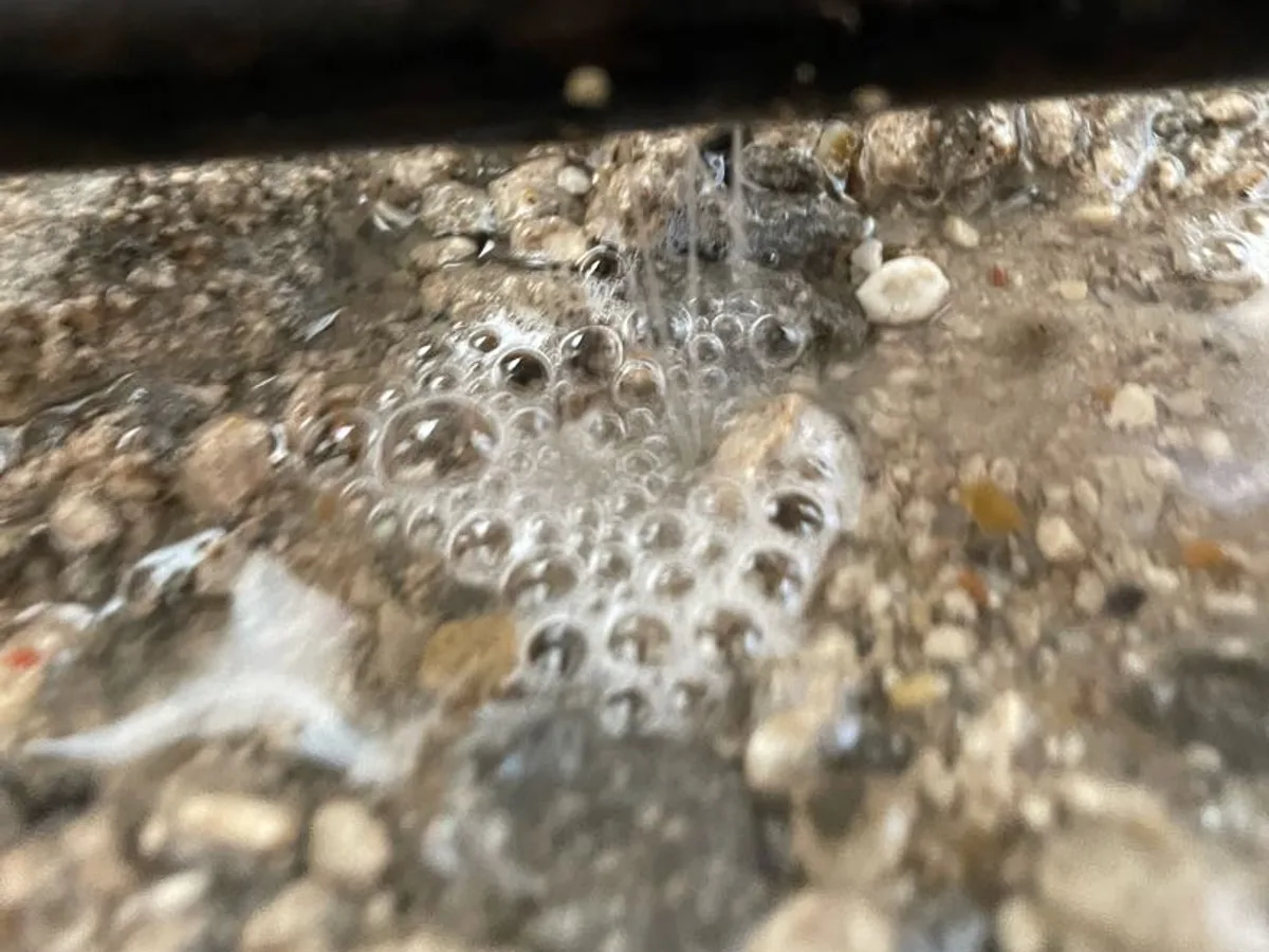 leak identified at copper pipe below concrete slab with water jetting from pinhole fault