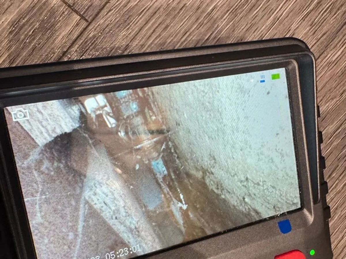 leak located at corroded tee piece fitting viewed on endoscope camera screen beneath kitchen unit