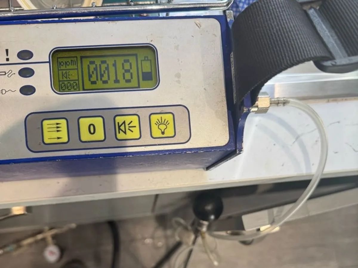 gas analyser displaying tracer gas ppm reading under kitchen unit during leak detection