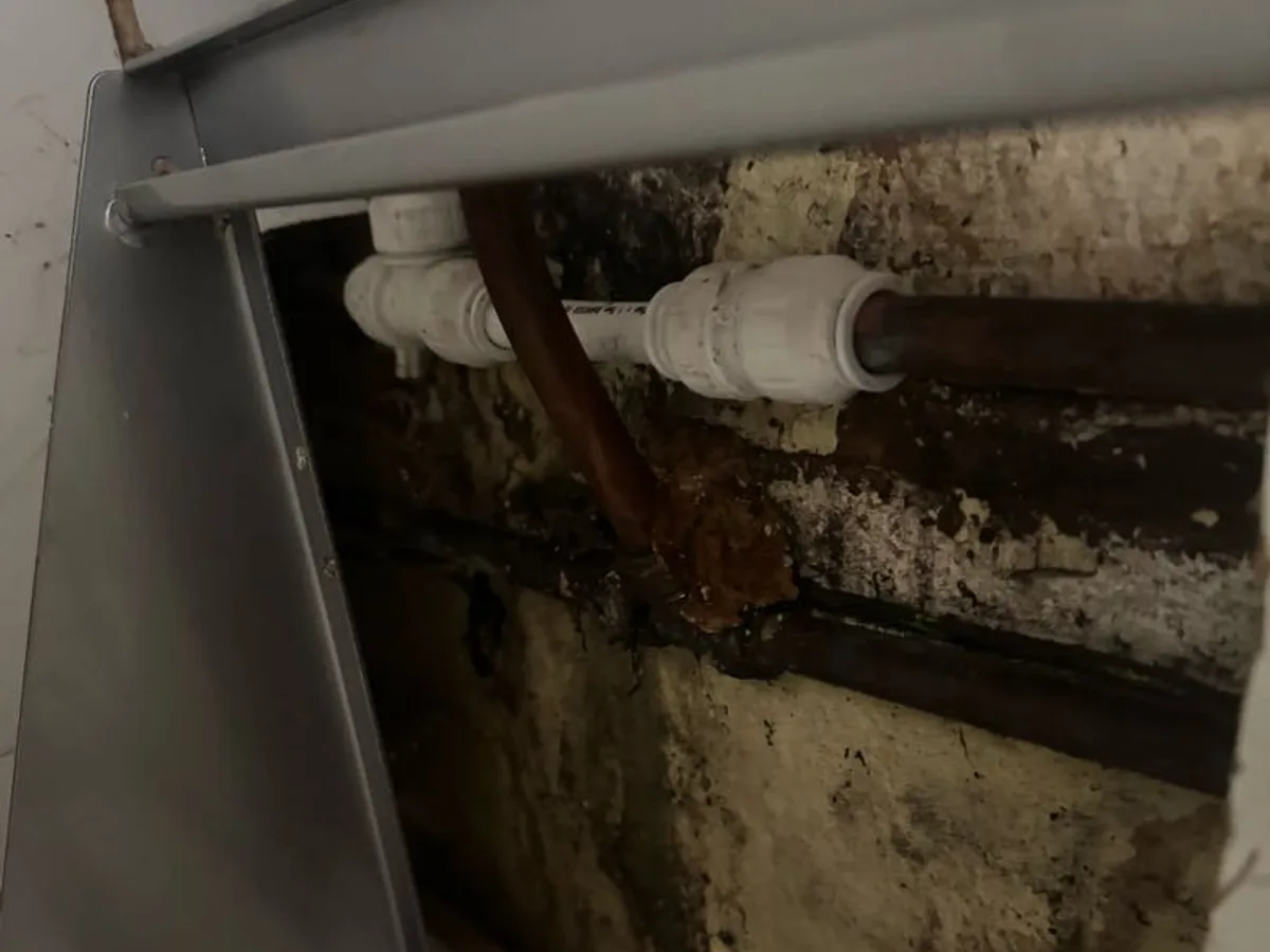 new push-fit couplings installed on cold mains pipework as repair completed beneath kitchen unit