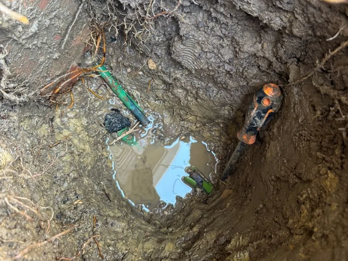 leak located at waterlogged excavation showing corroded pipework ends in saturated ground