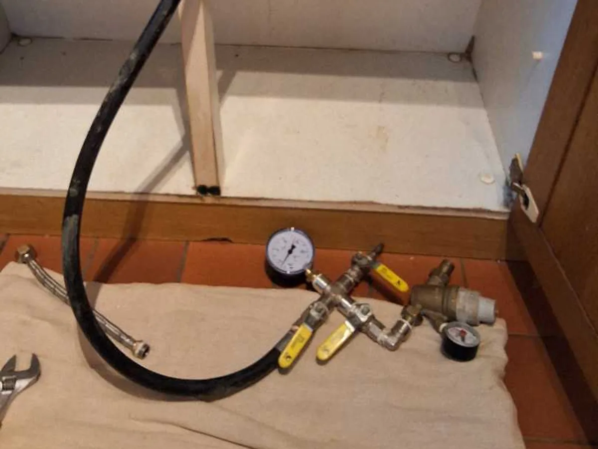 pressure test manifold and gauge connected under kitchen sink during leak detection