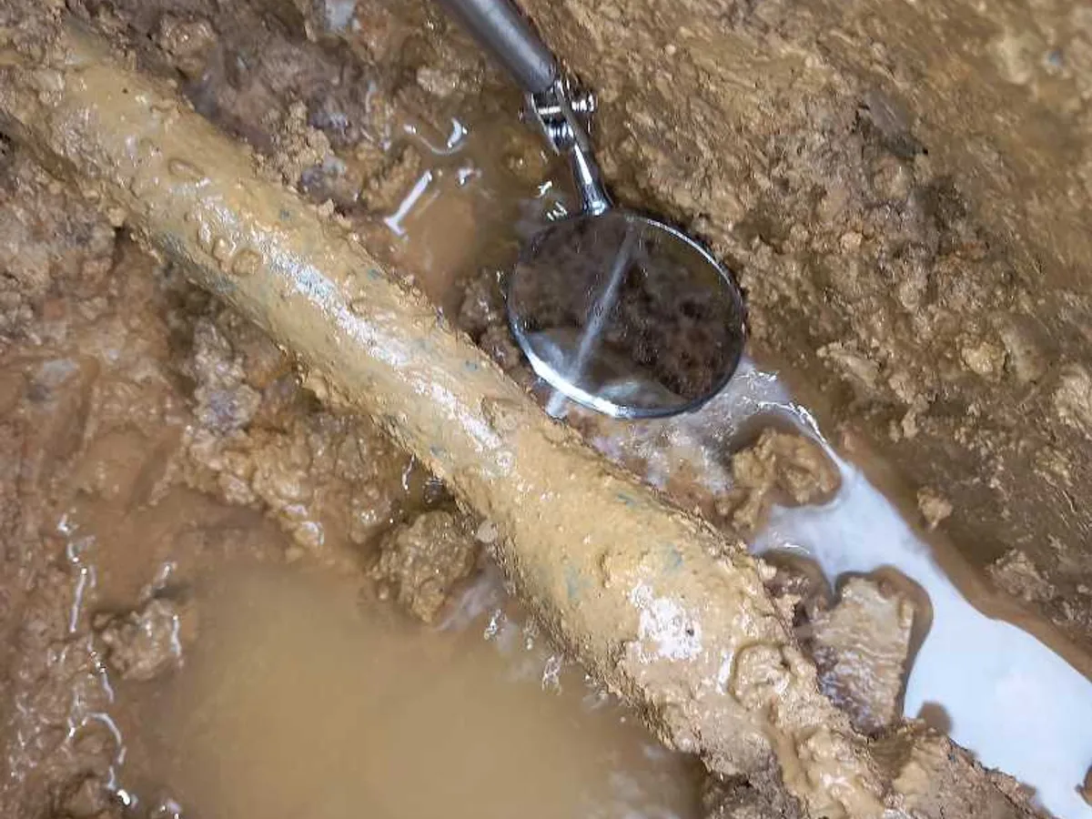fault identified at old lead mains pipe beside external stopcock with water actively escaping — leak located at