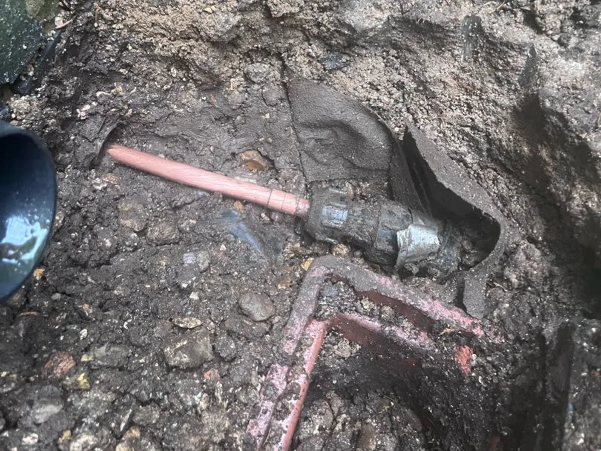 fault exposed at copper pipe junction in waterlogged ground after floor slates removed