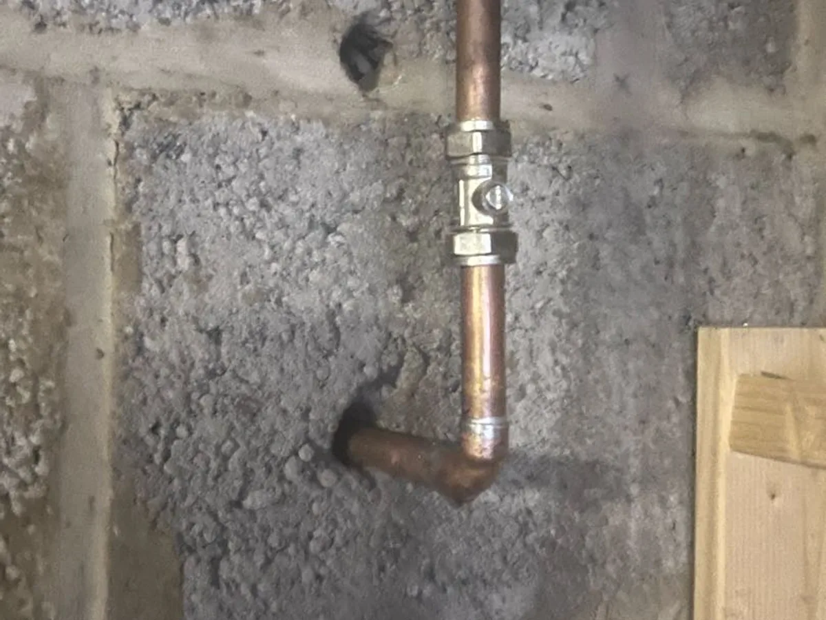 new isolation valve fitted to replaced copper pipe section through garage wall repair completed