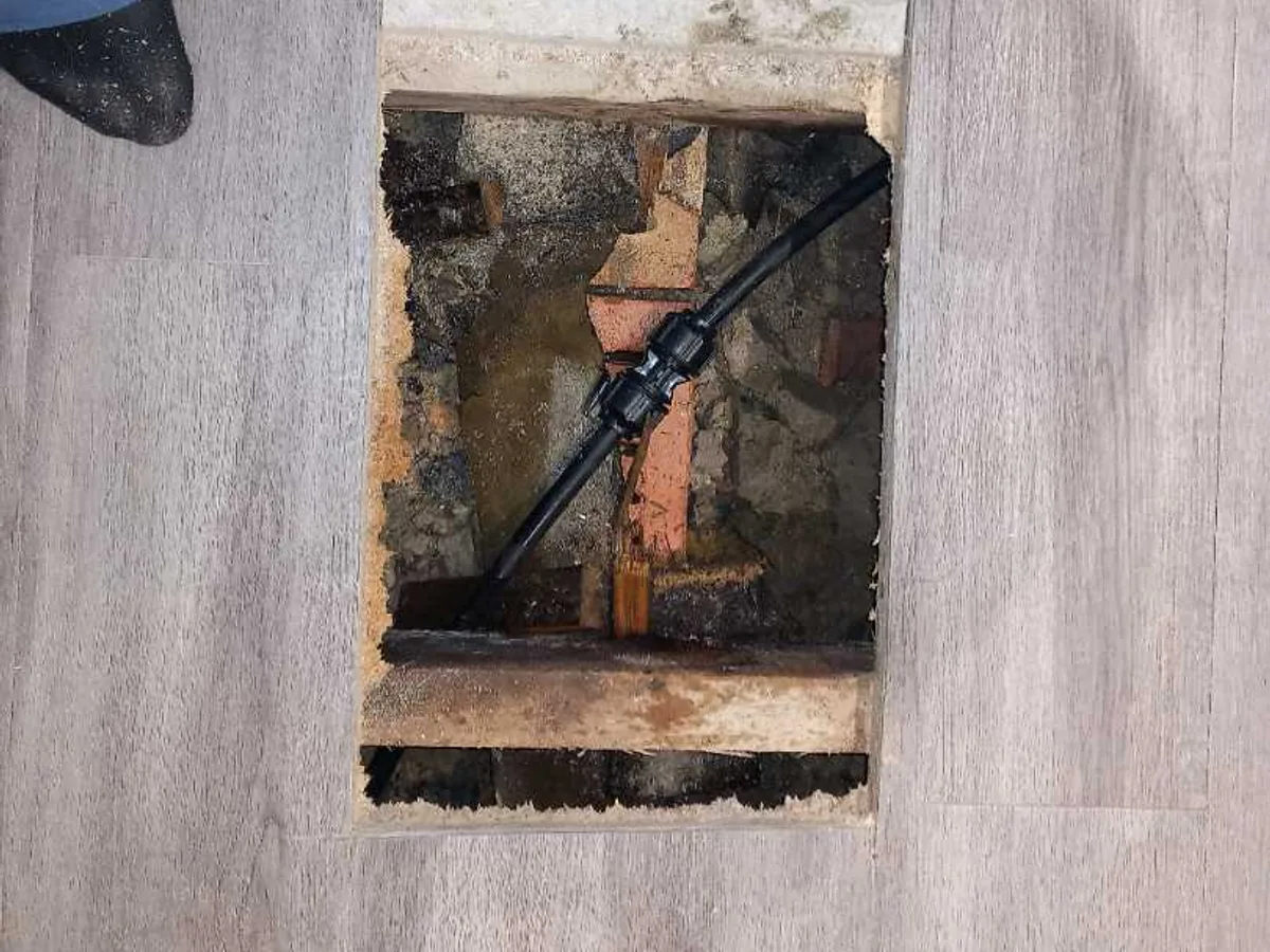 repair completed with new compression coupling fitted to black plastic mains pipe in floor void
