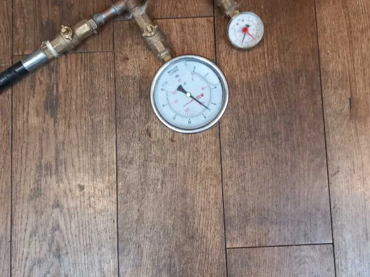 pressure test rig with gauge on wooden floor during leak detection