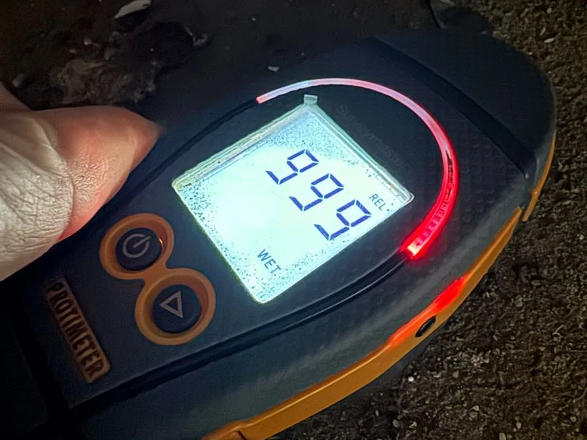 damp meter reading at maximum wet level on concrete floor during leak detection survey