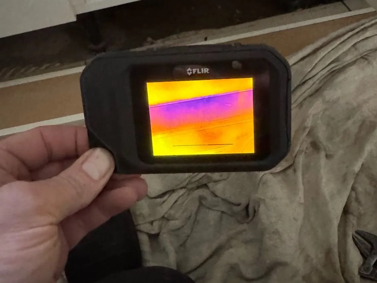 thermal imaging camera displaying cold patch beneath kitchen units during leak detection