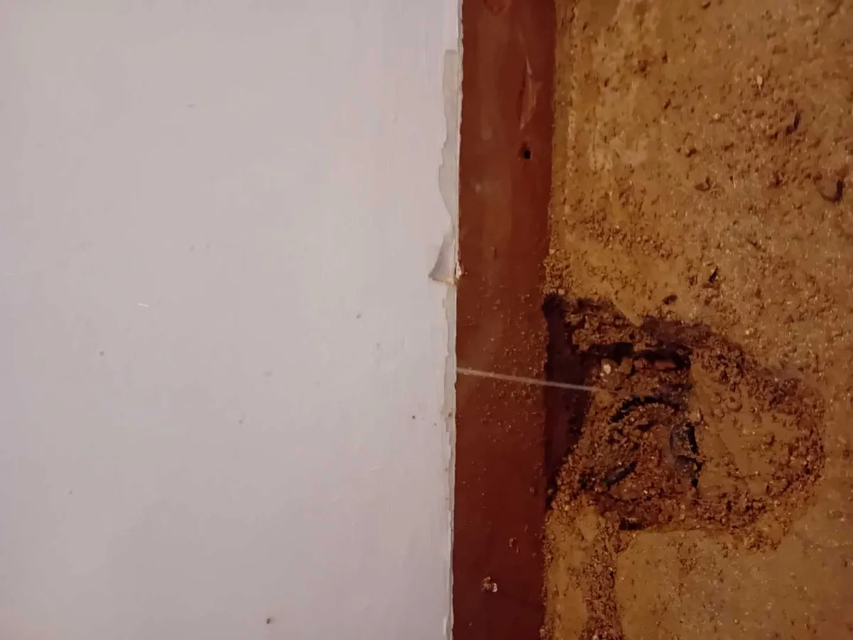 leak located at corroded copper pipework exposed beneath hallway floor skirting