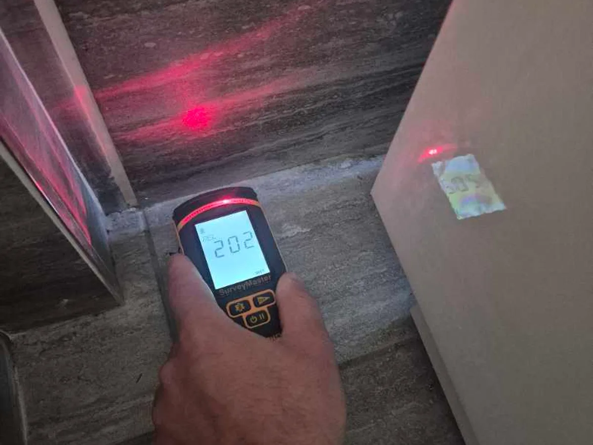 moisture meter being used on bathroom tiled floor during leak detection