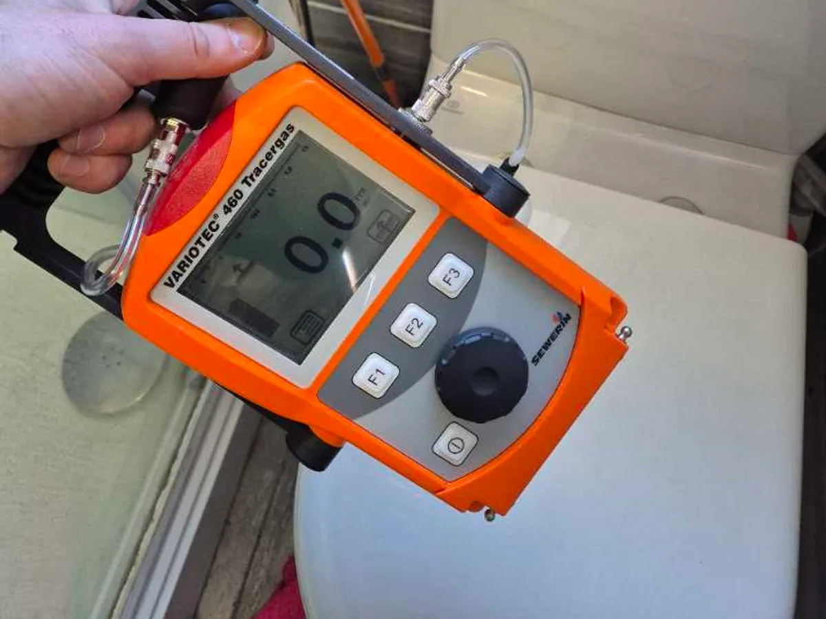 tracer gas detector showing zero reading in bathroom during leak detection survey