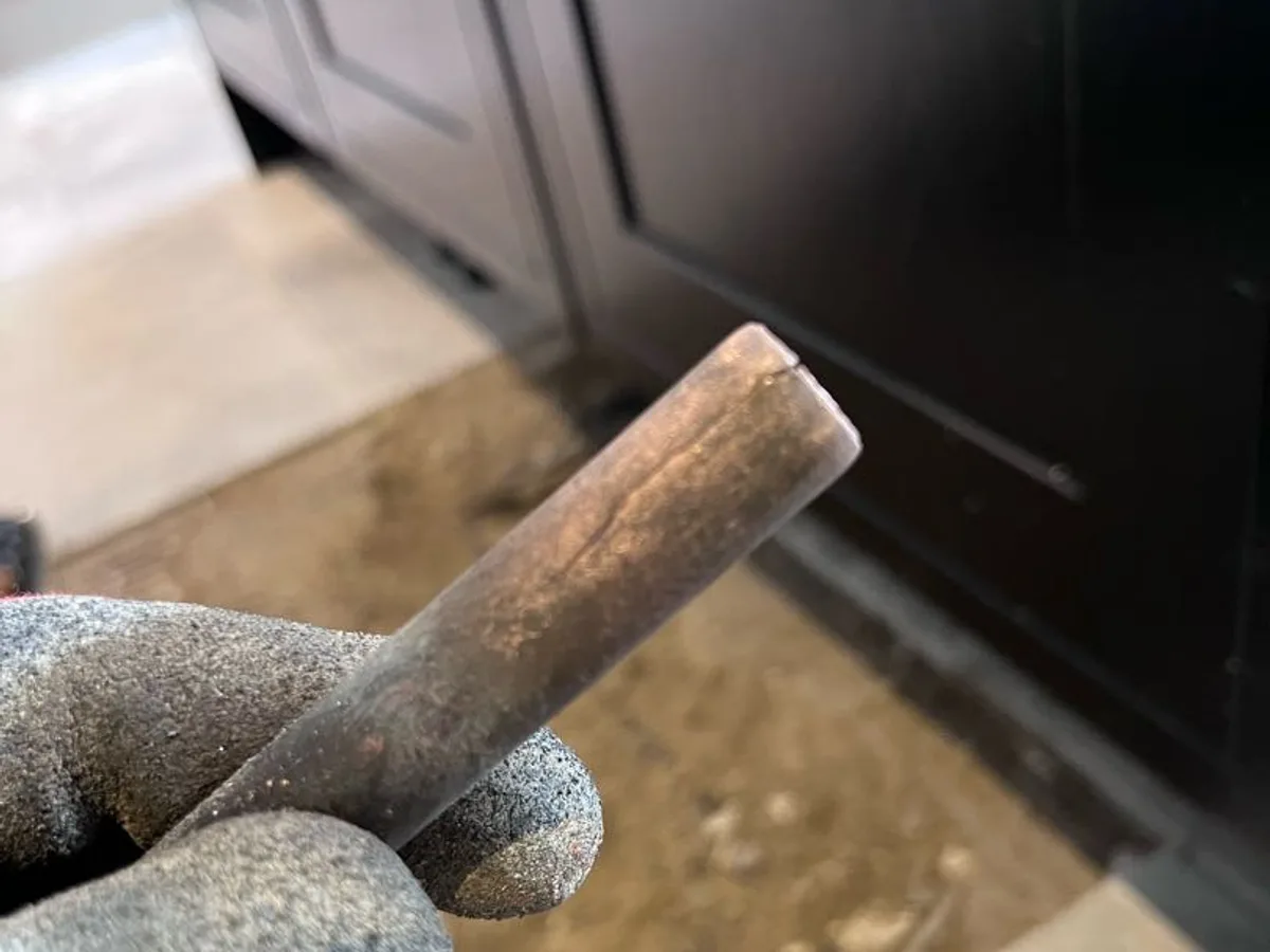 fault identified at split end of 15mm copper pipe removed from beneath kitchen island — leak located at