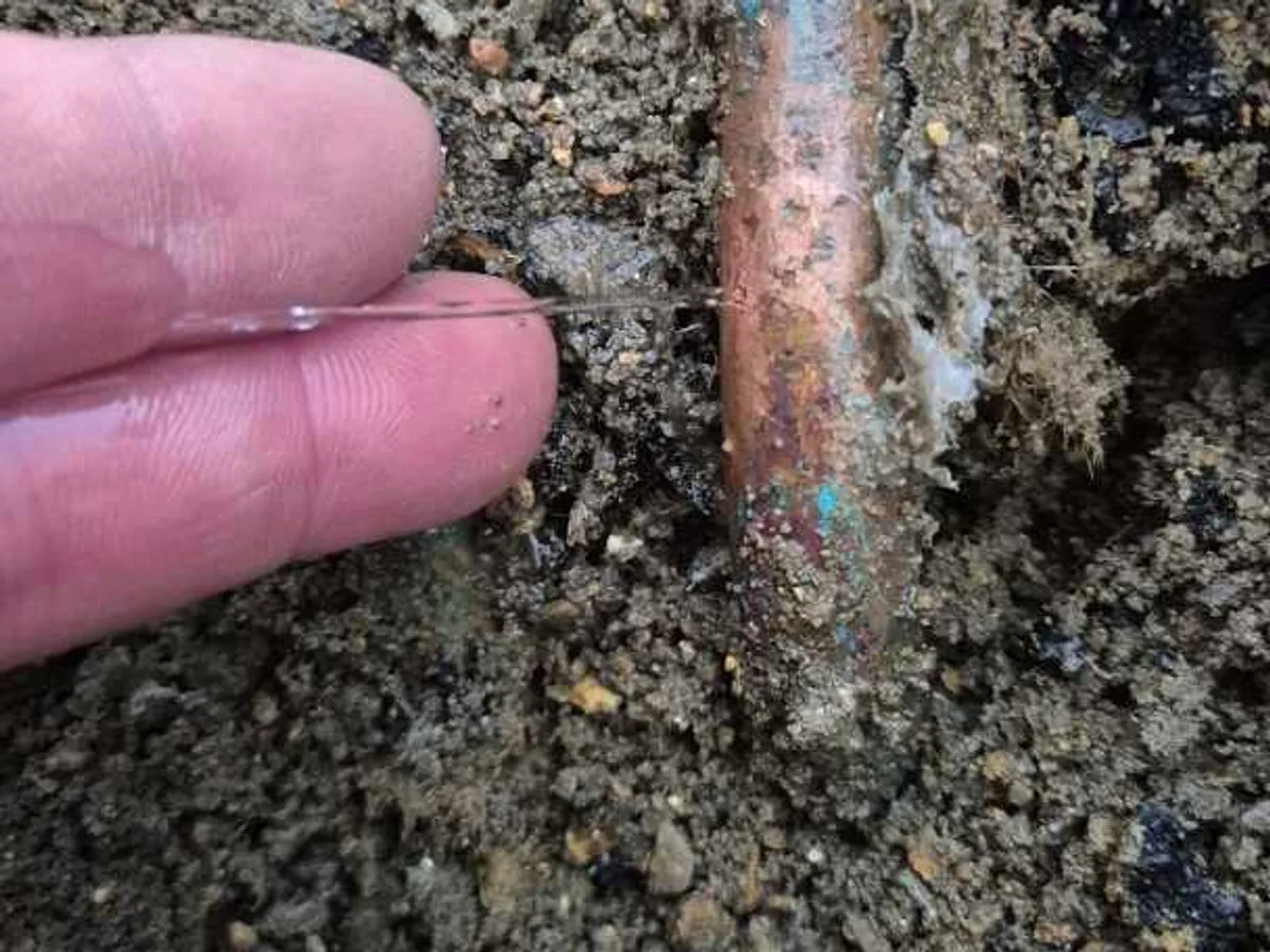 leak found at heavily corroded section of 15mm copper mains supply pipe in soil below floor