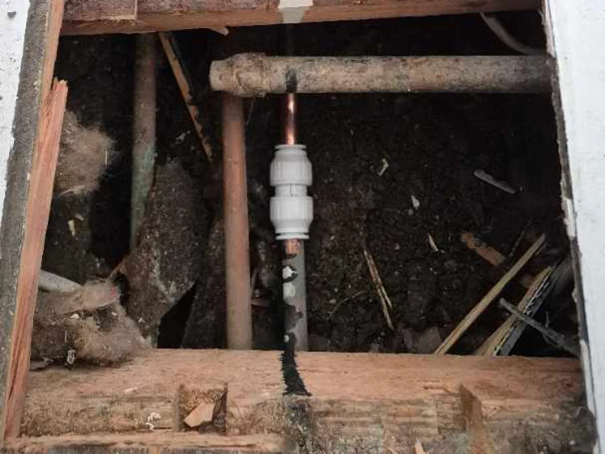 replacement 15mm copper pipe section with push-fit fitting repair completed beneath kitchen floor