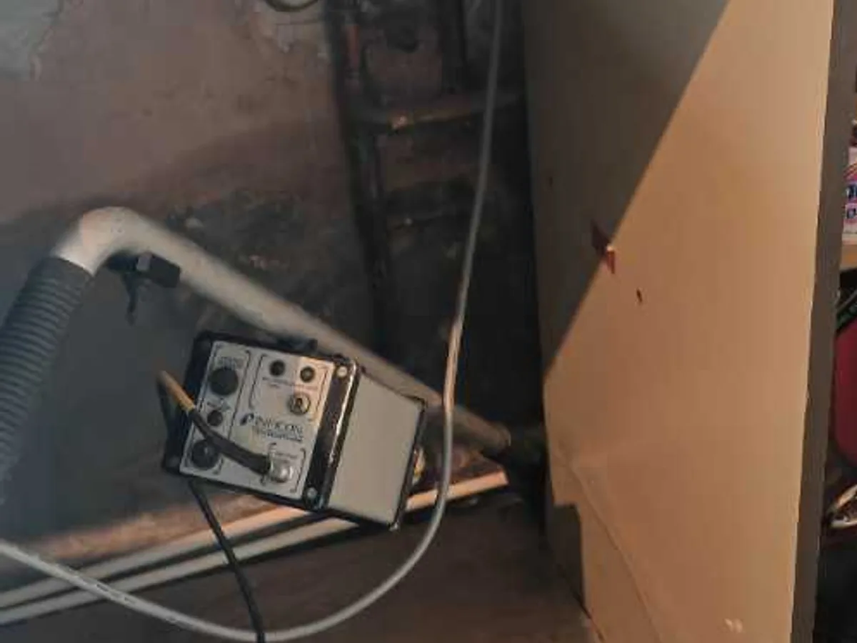 tracer gas analyser deployed beneath kitchen unit under sink during leak detection