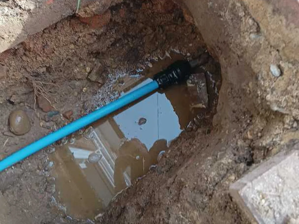 driveway excavation backfilled with new blue mains pipe visible after works completed