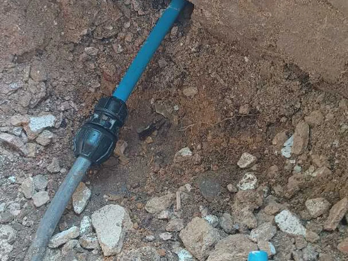new Philmac UTC coupling fitted to blue mains pipe as repair completed in excavated trench