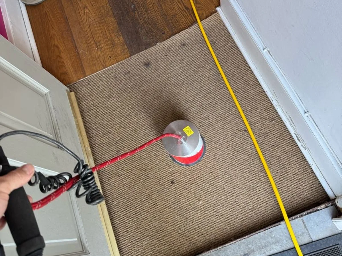 acoustic listening microphone placed on floor mat at front door during leak detection