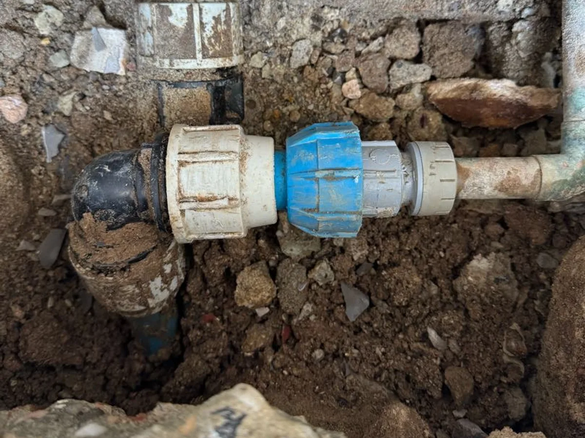 new 32mm compression fitting installed in excavated trench as repair completed