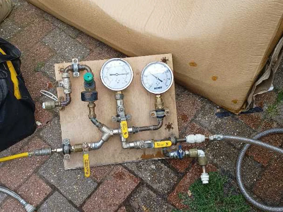 dual-gauge pressure test kit connected to mains pipework during leak detection survey