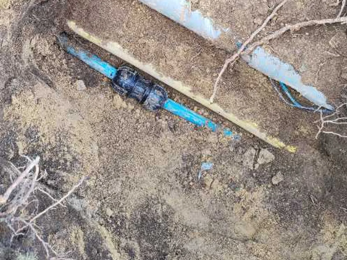 specialist transition coupling installed on blue mains supply pipe as repair completed