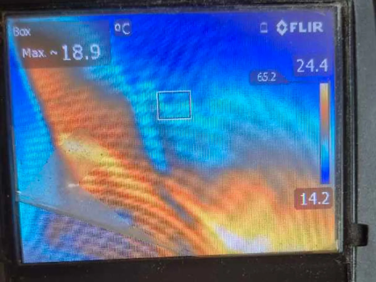 thermal imaging camera screen showing heat mass around pipework beneath floor during leak detection
